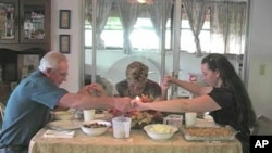 A family prays before Thanksgiving dinner.