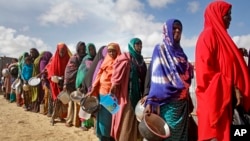 Women who fled drought queue to receive food distributed by local volunteers at a camp for displaced persons in the Daynile neighborhood on the outskirts of Mogadishu, in Somalia, May 18, 2019. 