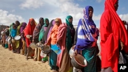 Women who fled drought queue to receive food distributed by local volunteers at a camp for displaced persons in the Daynile neighborhood on the outskirts of Mogadishu, in Somalia, May 18, 2019. 