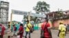 FILE - People, some wearing masks, walk by the entrance to Yaounde General Hospital, in Yaounde, Cameroon, March 6, 2020, amid the coronavirus pandemic. 