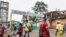 FILE - People, some wearing masks, walk by the entrance to Yaounde General Hospital, in Yaounde, Cameroon, March 6, 2020, amid the coronavirus pandemic. 