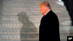 FILE - President Donald Trump arrives on the South Lawn of the White House, in Washington, Jan. 12, 2021.