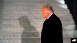 FILE - President Donald Trump arrives on the South Lawn of the White House, in Washington, Jan. 12, 2021.