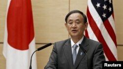 Japan's Chief Cabinet Secretary Yoshihide Suga speaks during a joint media briefing about the process of U.S. forces consolidation in Okinawa, in Tokyo, Dec. 4, 2015.