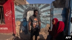 Higino Fumo, 32 anos, conhecido no mundo do rap como “Nikotina”, olha ao lado de um mural em memória do rapper Mano Azagaia e crítico da Frelimo, morto em 2023, em Maputo, a 3 de dezembro de 2024.