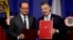 France's President Francois Hollande (L) and his Colombian counterpart Juan Manuel Santos pose for photographs with signed agreements during a joint news conference at the presidential palace in Bogota, Colombia, Jan. 23, 2017. 