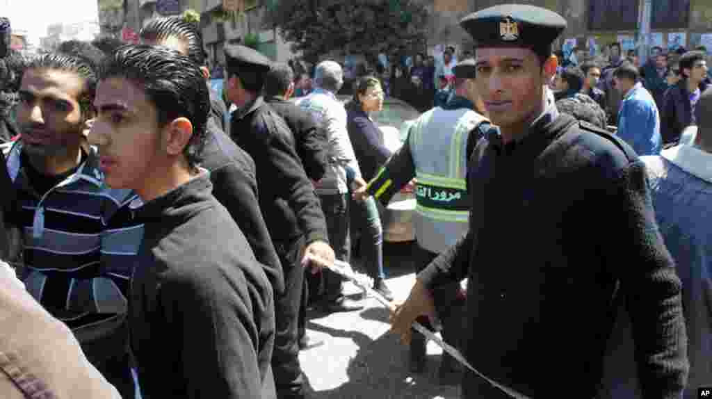 Security helps manage the tens of thousands who came to mourn the Coptic patriarch. (VOA-E. Arrott)