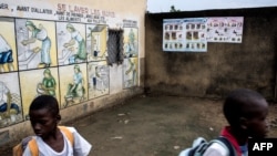 Des enfants marchent devant des panneaux écrits en français, à Kinshasa, en RDC, le 18 janvier 2018.