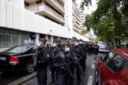 FILE - French police officers patrol the area after a knife attack near the former offices of satirical newspaper Charlie Hebdo, Sept. 25, 2020, in Paris.