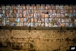 Photographs of Israeli hostages being held by Hamas militants are projected on the walls of Jerusalem's Old City, Monday, Nov. 6, 2023. 