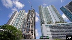 A high-rise building under construction is shown next to high-rise condominium buildings, Sept. 7, 2017, in downtown Miami.