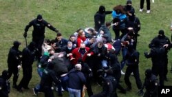 People clash with policemen during an opposition rally to protest the official presidential election results in Minsk, Belarus, Oct. 11, 2020.