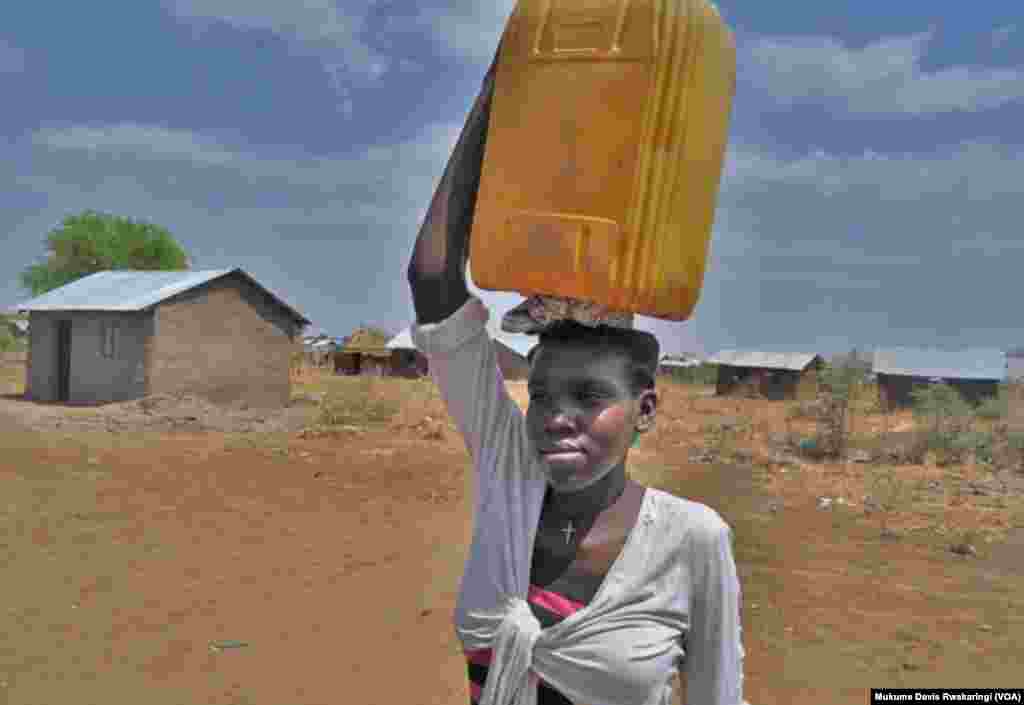 A young woman carries a plastic container to collect water in Gudere, near Juba in South Sudan. Only half the population of South Sudan has access to clean water. (VOA/Mugume Davis Rwakaringi)