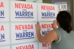 20일 미국 네바다주 라스베이거스의 선거유세장에 미국 민주당 대선 경선 후보인 엘리자베스 워런 상원의원의 지지자가 선전 포스트를 유리창에 붙이고 있다.
