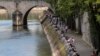 Orang-orang berjalan di sepanjang tepi sungai Seine di Paris, 21 Mei 2020 ketika Perancis secara bertahap melonggarkan karantina wilayah akibat Covid-19. (Foto: AP / Michel Euler)