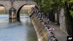 Orang-orang berjalan di sepanjang tepi sungai Seine di Paris, 21 Mei 2020 ketika Perancis secara bertahap melonggarkan karantina wilayah akibat Covid-19. (Foto: AP / Michel Euler)