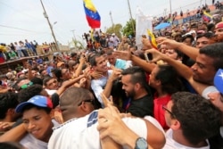 FILE - Juan Guaidó, opposition leader and self-proclaimed interim president of Venezuela, is surrounded by supporters at the end of a rally on the shore of Lake Maracaibo in Cabimas, Venezuela, April 14, 2019.