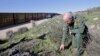 FILE - Border Patrol agent Richard Gordon, a 23-year veteran of the agency, examines broken dried branches that indicate human traffic near the border fence where illegal immigrants enter the United States in the Boulevard area east of San Diego, California, March 25, 2013.
