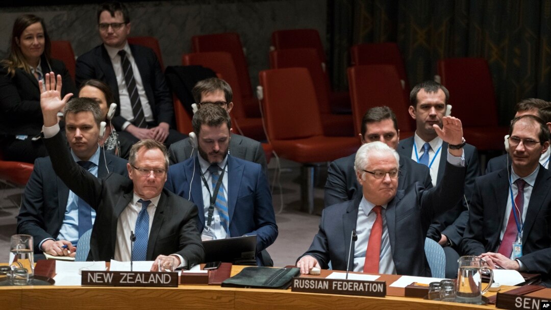 New Zealand's U.N. Ambassador Gerard van Bohemen, left, and Russia's ambassador to the U.N., Vitaly Churkin, raise their hands as they join other members of the Security Council at the United Nations headquarters in passing a resolution supporting efforts