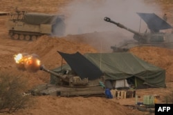 FILE - An Israeli army self-propelled artillery howitzer fires rounds from a position near the border with the Gaza Strip in southern Israel on December 28, 2023 amid ongoing battles between Israel and the Palestinian militant group Hamas.