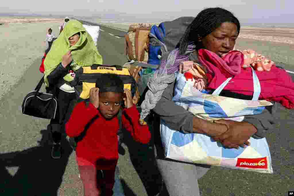 Migrants from Venezuela walk on the shoulder of a highway after crossing into Chile from the Bolivian border, near Colchane, Chile, Feb. 6, 2021.