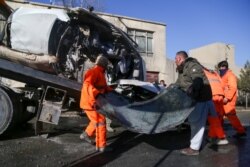 Municipal workers clean up debris at the site of a bomb attack in Kabul, Dec. 22, 2020.