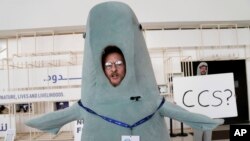 FILE - A person in a dugong costume stands near a sign that says CCS, carbon capture and storage, at the COP28 U.N. Climate Summit, Monday, Dec. 11, 2023, in Dubai, United Arab Emirates.