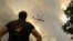 A helicopter flies over a wildfire in Giannouli, in the Evros region of Greece, on Aug. 31, 2023. Greek authorities have reinforced firefighting forces in the country's northeast, where a massive blaze in its 13th day has flared up again. (e-evros.gr via AP)