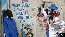 Southern Sudanese artists stand next to a painted sign in the southern capital of Juba urging people to register for the upcoming independence referendum, 30 Sep 2010