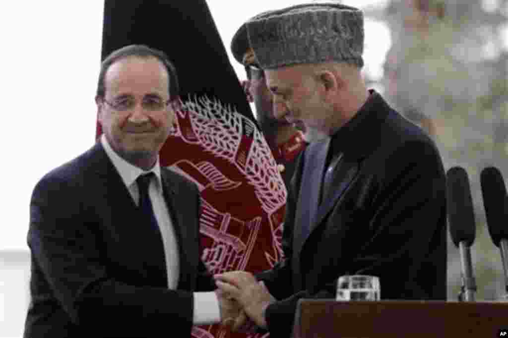 Afghan President Hamid Karzai, right, shakes hands with French President Francois Hollande after their joint press conferencl in Kabul, Afghanistan, Friday, May, 25, 2012. Hollande announced that his country's troops had carried out their mission in Afgha