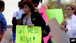 A Texas Health Presbyterian Hospital Dallas staff carries a sign wishing Nina Pham well, Oct. 16, 2014. (AP Photo/Tony Gutierrez)