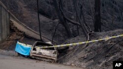 The remnants of burnt out car in which an elderly couple was killed sits by the side of the road where the couple was caught by a wildfire, in the village of Relvas near Santa Comba Dao, northern Portugal, Oct. 16, 2017.