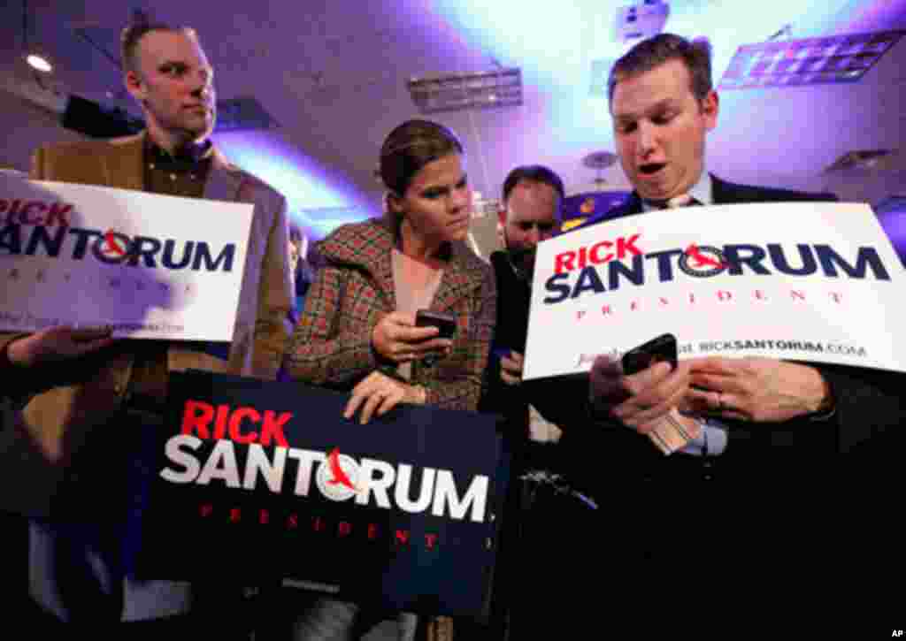 Supporters of Rick Santorum compare Iowa caucus returns at the Republican presidential candidate's victory party. (AP)