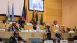 FILE - African Union chairman Moussa Faki (2nd L-top) sitting with members of the Intergovernmental Authority for Development (IGAD) as they attend a signing ceremony for the ceasefire agreement among South Sudanese parties to end the four-year war in the country, at the headquarters of African Union in the Ethiopian capital Addis Ababa, Dec. 21, 2017.