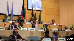 FILE - African Union chairman Moussa Faki (2nd L-top) sitting with members of the Intergovernmental Authority for Development (IGAD) as they attend a signing ceremony for the ceasefire agreement among South Sudanese parties to end the four-year war in the country, at the headquarters of African Union in the Ethiopian capital Addis Ababa, Dec. 21, 2017.