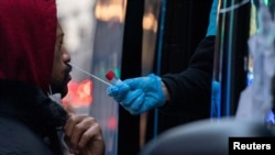 Seorang pria melakukan tes COVID-19 di lokasi pengujian saat varian virus corona omicron terus menyebar di Manhattan, New York City, AS, 27 Desember 2021. (Foto: REUTERS/Jeenah Moon)