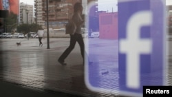 FILE - The Facebook logo is seen on a shop window in Malaga, Spain, June 4, 2018.