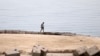 FILE - A man walks along one of the beaches that have been closed after a Russian citizen was killed in a shark attack near a beach at the Egyptian Red Sea resort of Hurghada, June 9, 2023.