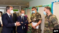French Health Minister Olivier Veran (L) and French Overseas Minister Sebastien Lecornu (2nd L) talk with military medical staff during a visit at the CHU hospital in Fort-de-France, Martinique, on Aug. 12, 2021. 