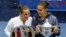 Childhood friends Flavia Pennetta, right, and Roberta Vinci pose with their awards after Pennetta won their women's championship match of the U.S. Open tennis tournament in New York, Sept. 12, 2015.