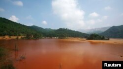 Sebuah danau yang terkontaminasi dan terlihat berwarna merah kecoklatan di provinsi Guangdong (Foto: dok).