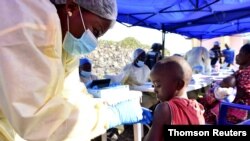 A Congolese health worker administers ebola vaccine to a child at the Himbi Health Center in Goma, July 17, 2019.