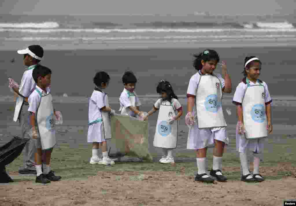 School children collect rubbish from Karachi&#39;s Clifton beach early morning April 22, 2013, during a cleaning campaign as part of the commemoration of Earth Day. 