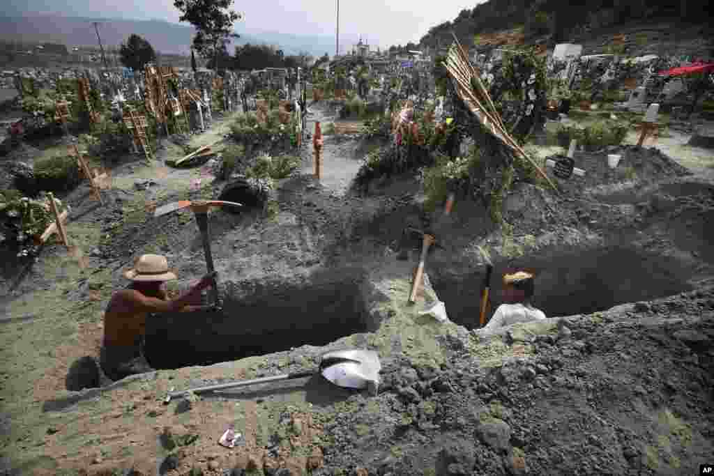 Men dig graves at the Valle de Chalco cemetery during the new coronavirus pandemic on the outskirts of Mexico City, March 31, 2021.