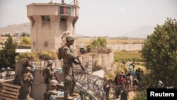 U.S. Marines stand guard at an Evacuee Control Checkpoint at Hamid Karzai International Airport, Kabul, Afghanistan, in this photo taken on August 20, 2021. Sgt. Victor Mancilla/U.S. Marine Corps/Handout via REUTERS THIS IMAGE HAS BEEN SUPPLIED BY A THIR