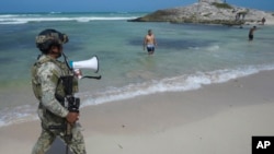 Un soldado pide a los turistas que evacuen la playa Mirador antes de la llegada prevista del huracán Beryl, en Tulum, México, el 4 de julio de 2024.