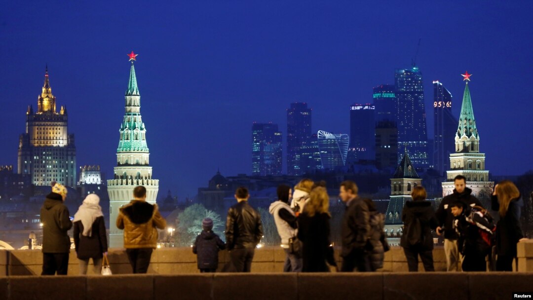 FILE - People stand on the Great Moskvoretsky Bridge, with the headquarters of Russian Foreign Ministry seen in the background, in central Moscow, Russia, March 28, 2016. 