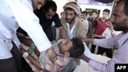 Medics and other men carry an injured tribesman loyal to tribal leader Shiekh Sadiq al-Ahmar after clashes with police forces outside al-Ahmar's house in Sanaa, May 31, 2011