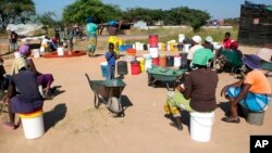 FILE - Omama labantwana badinga amanzi.