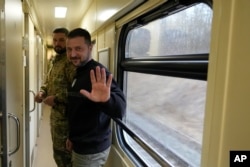 烏克蘭總統澤連斯基在前往基輔的火車上接受美聯社記者的採訪後與記者道別。（2023年3月28日）